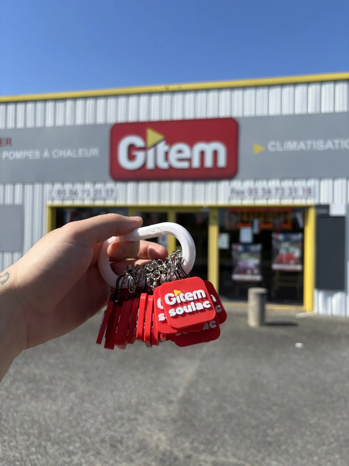 Trousseau de porte-clés Gitem Soulac imprimés en 3D par Filon Médoc, photographié devant le magasin