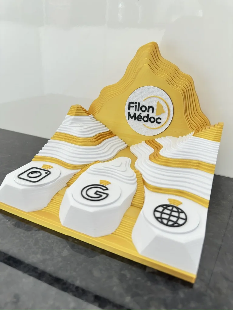 Filon Médoc NFC stand in gold and white PLA, raised logo medallion and 3 clip-on contactless shortcuts (Instagram, Google reviews, website) over their NFC chips